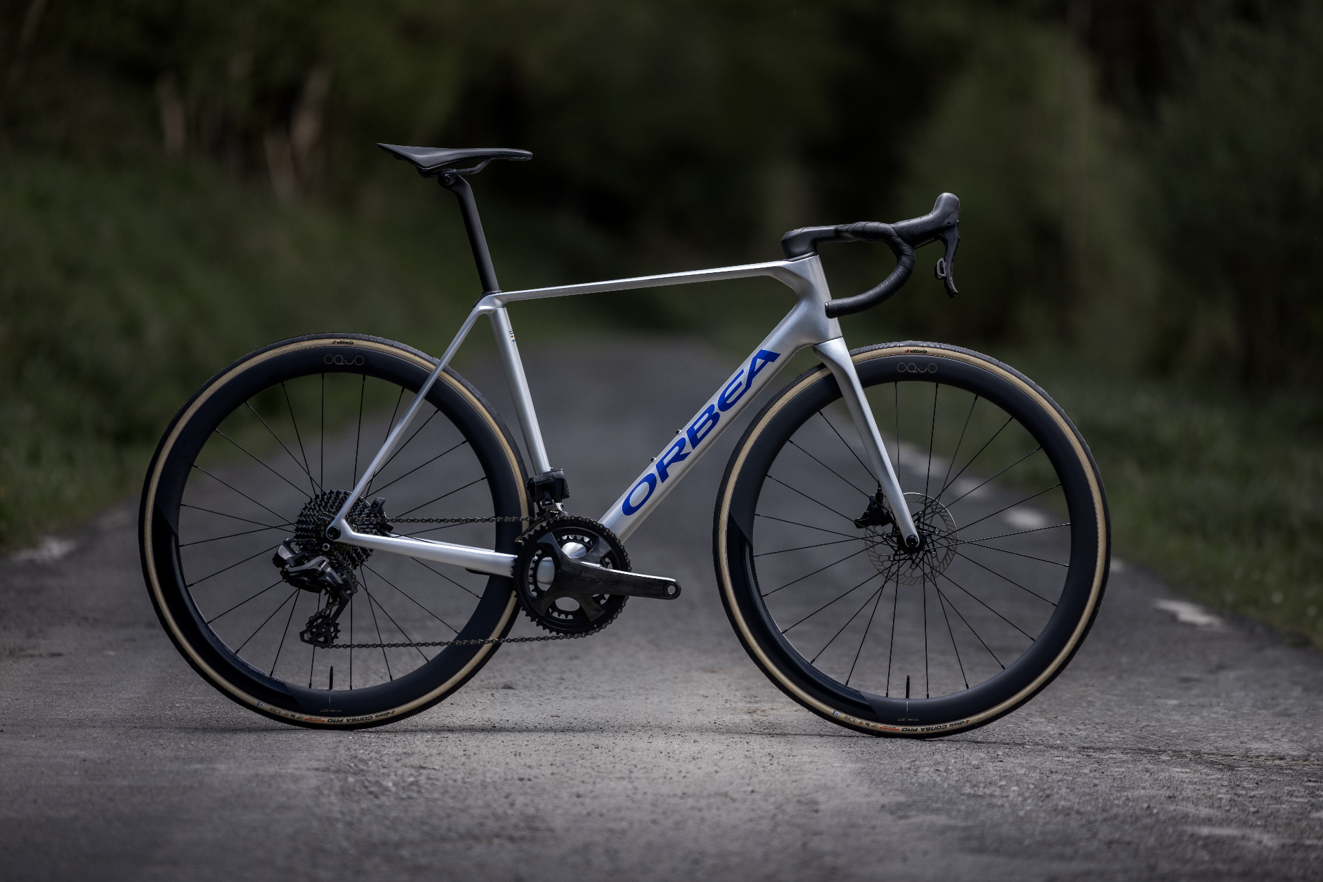 Orbea Orca silver carbon road bike on a country road
